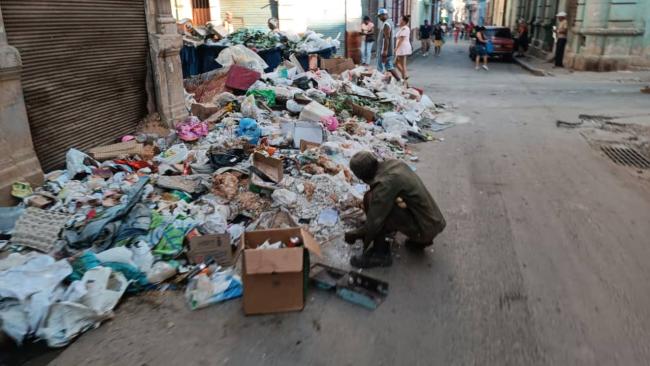 Un cubano escarbando en la basura.