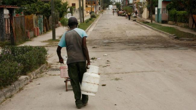 Un hombre carga con balitas de gas en La Habana.