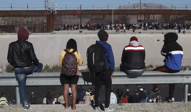 Migrantes observan a otros junto al muro fronterizo en Ciudad Juárez, México, el miércoles 21 de diciembre de 2022.