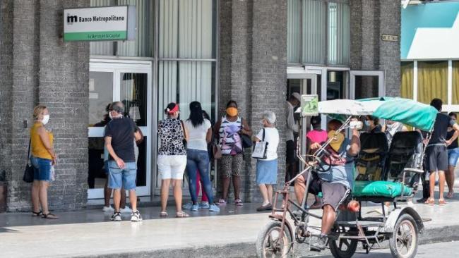 Cubanos esperan en una sucursal de un banco.