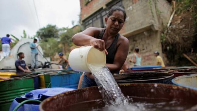Mujer venezolana almacenando agua.