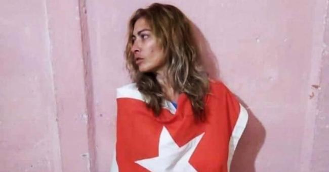 La activista Aniette González envuelta en la bandera cubana.