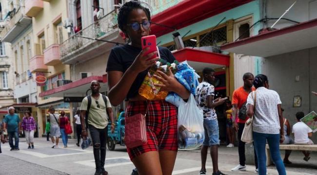 Una mujer carga mercancías en una calle comercial de La Habana el 16 de agosto, 2023.