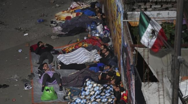 Migrantes duermen en una estación mientras esperan un tren con destino al norte de México.