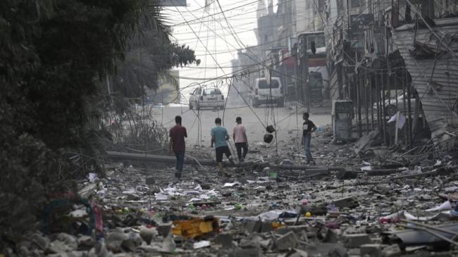 Un grupo de palestinos en una zona arrasada por los ataques israelíes en Gaza. 