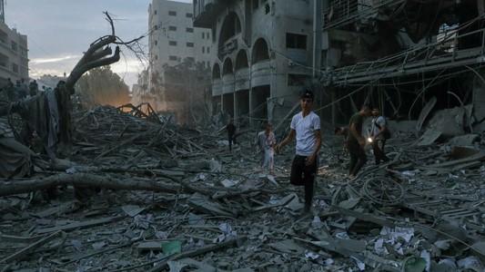 Palestinos inspeccionan los alrededores destruidos de la Torre de Palestina. 