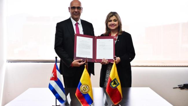 El embajador de Cuba en Colombia, Javier Caamaño, y la secretaria de Educación Distrital de Bogotá, Edna Bonilla, tras firmar el acuerdo.