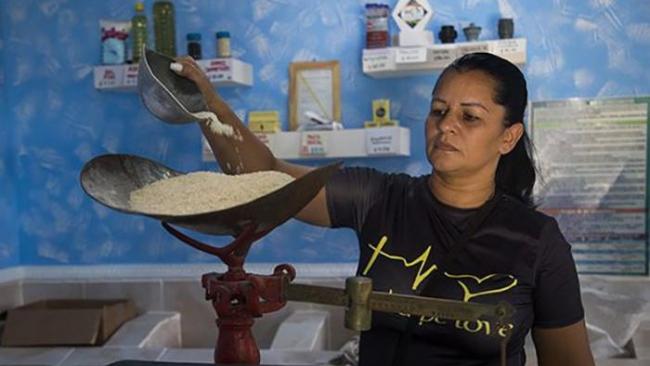 Una bodeguera despacha el arroz racionado a un consumidor.