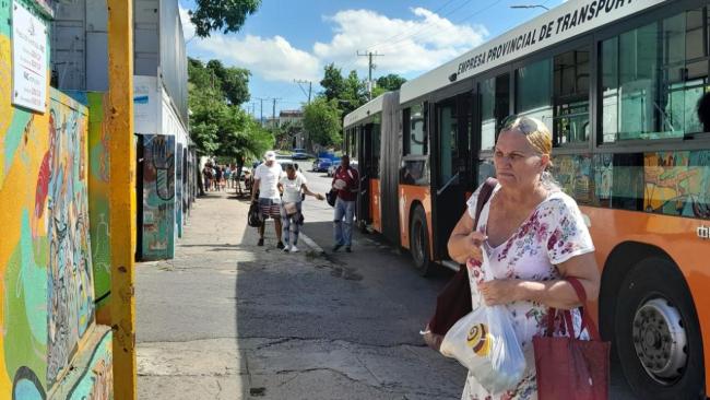 Una mujer baja de un ómnibus en La Habana.