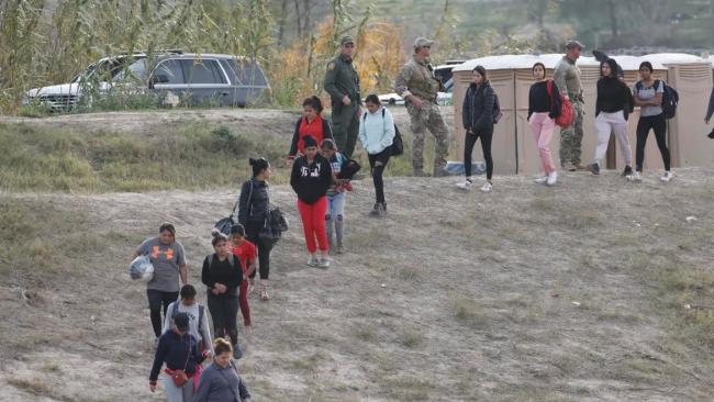 Migrantes caminan en Shelby Park, en Eagle Pass, Texas (EEUU)