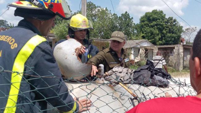 Bomberos y funcionarios en el depósito de gas afectado.