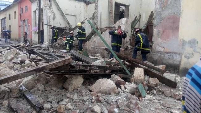 Los bomberos trabajan entre los escombros del derrumbe.