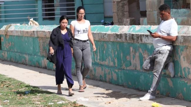 Mujeres cubanas caminan por una calle.