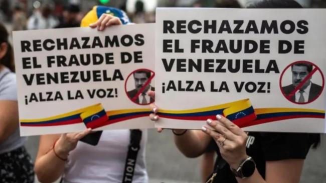 Dos personas protestan contra el resultado de las elecciones en Venezuela.