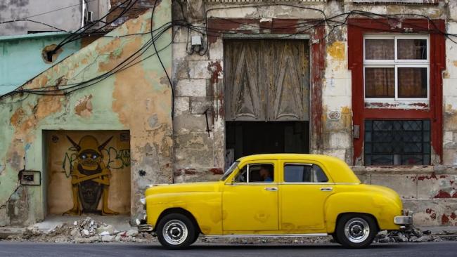 Dos tipos de propiedad: carro restaurado y edificios en ruinas.