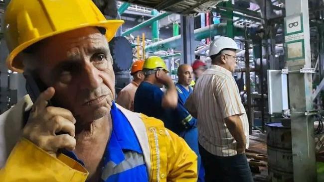 El director de la Unión Eléctrica, Alfredo López, y el ministro de Energía y Minas, Vicente de la O Levy, junto a funcionarios de la Termoeléctrica Antonio Guiteras, el miércoles 28 de agosto.