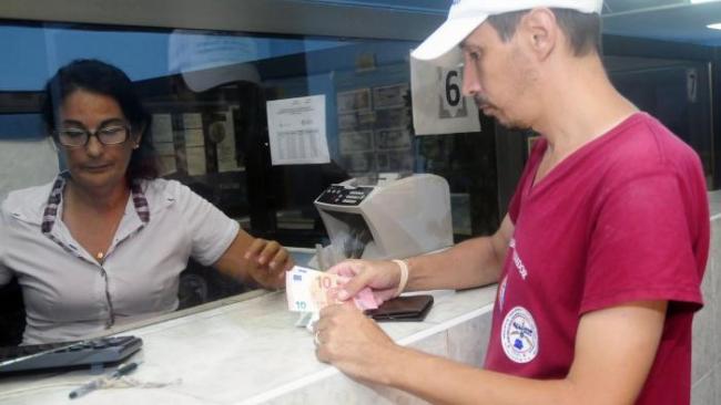 Un cubano cambia dinero en un banco del régimen.