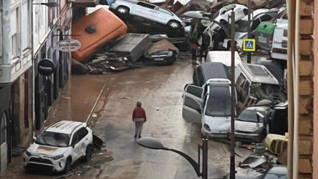 Una calle con vehículos destruidos por la DANA en España.