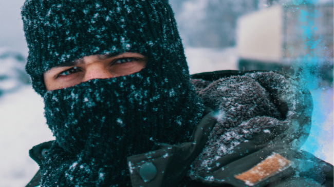 Hombre con pasamontañas bajo una nevada.