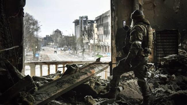 Un soldado ruso hace fotos entre las ruinas del teatro de Mariúpol, destruido por Rusia.