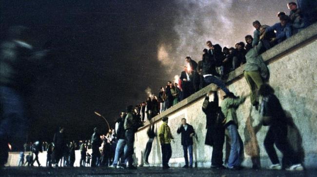 Ciudadanos de la antigua RDA sobre el Muro de Berlín.