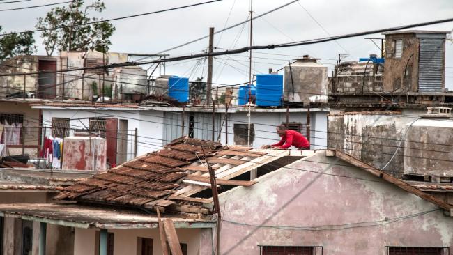 Un cubano residente en Artemisa examina los daños que dejó en su casa el huracán Rafael.