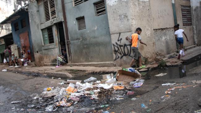 Niños en una esquina llena de basura en La Habana.