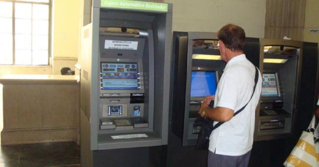 Una persona retira dinero de un cajero automático.