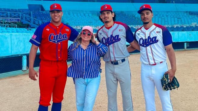 Lourdes Dávalos junto a peloteros cubanos en el Estadio Latinoamericano, de La Habana.