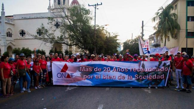 Trabajadores de la Oficina de Administración Tributaria de Cuba durante una marcha.