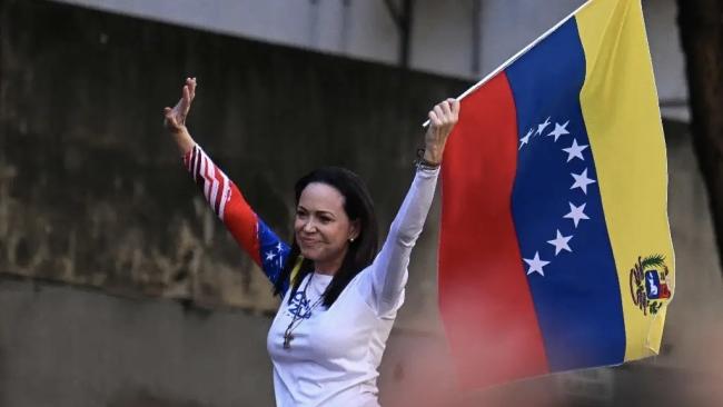 María Corina Machado con una bandera de Venezuela.