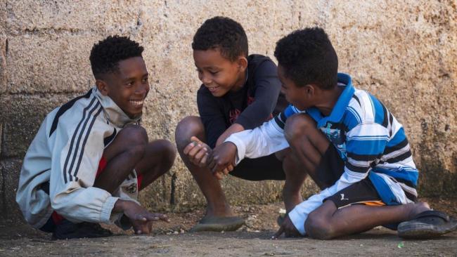 Tres niños matanceros juegan a las bolas durante un apagón.