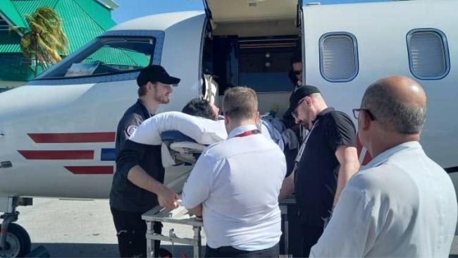 Traslado en camilla de Sylvie Beauchesne a un avión del aeropuerto.