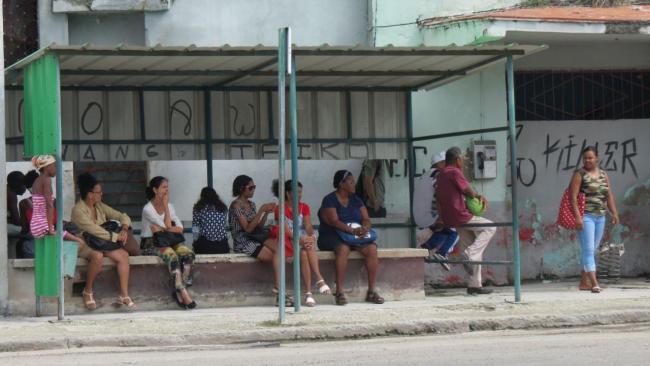 Pasajeros esperan por un ómnibus en una parada en La Habana.