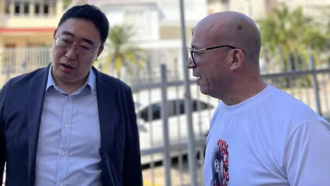 Randy Alonso (d) y un miembro de la delegación china.
