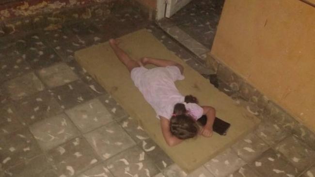 Una niña durmiendo en un portal durante un apagón en Cuba.