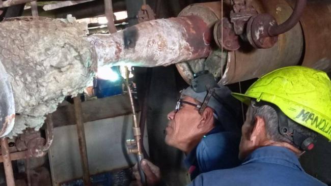 Trabajadores de la Termoeléctrica de Nuevitas examinan tuberías de la planta.