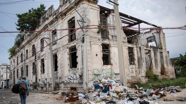 Un hombre pasa junto a un edificio en ruinas en La Habana.