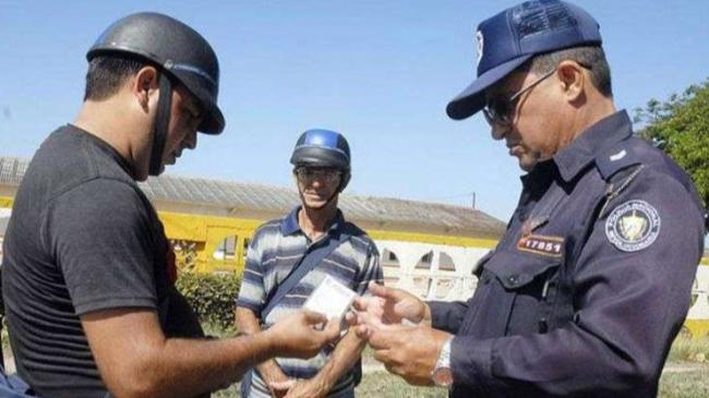 Un policía de tránsito cubano multa a un conductor.