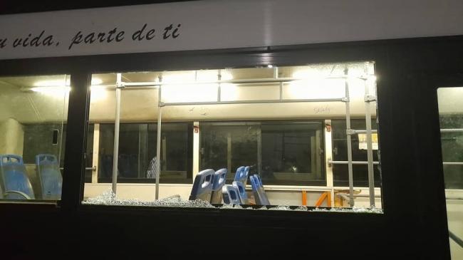 La ventanilla destruida del ómnibus atacado.
