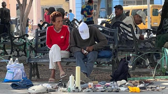 Dos cubanos venden objetos sacados de la basura en el parque El Curita, de La Habana.