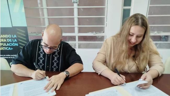 Randy Alonso y Daria Yuryeva firman el acuerdo en La Habana.