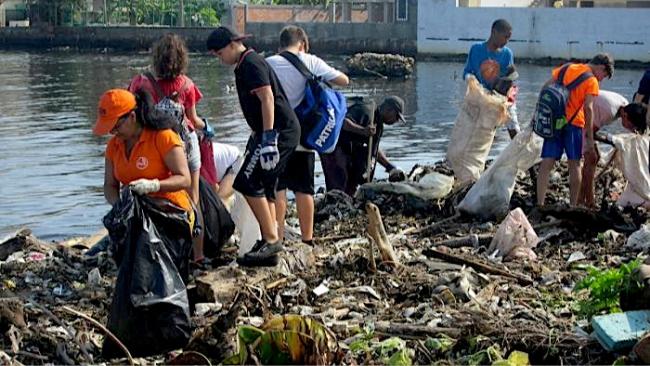 Voluntarios recogiendo desechos en la desembocadura del río Quibú. 