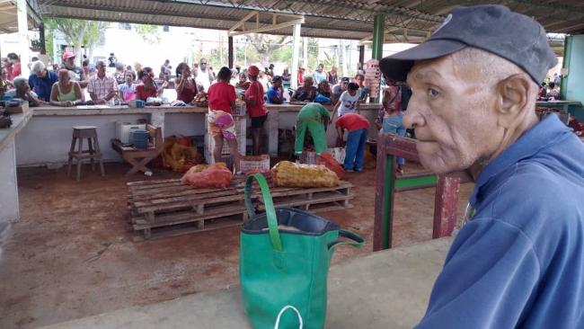 Un anciano espera su turno para comprar papas en Santiago de Cuba.
