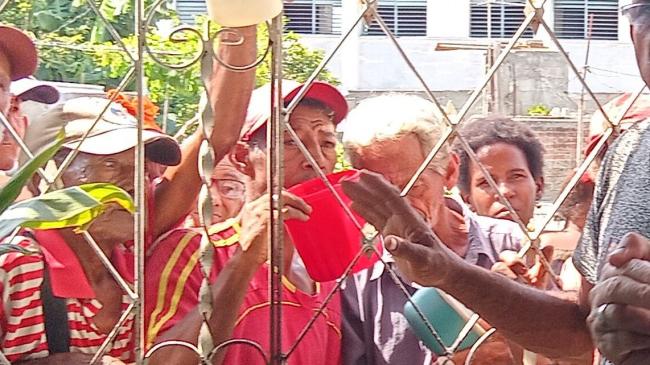 Personas vulnerables reciben alimentos en la sede de la UNPACU.