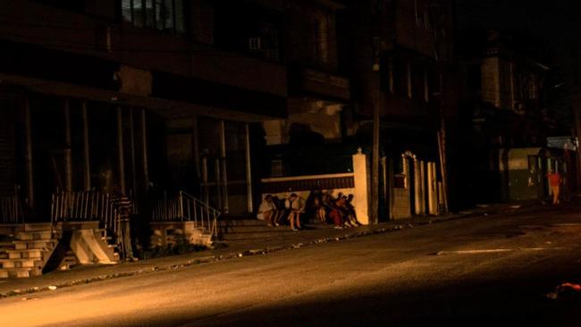 Un grupo de jóvenes en una calle de La Habana durante un apagón.