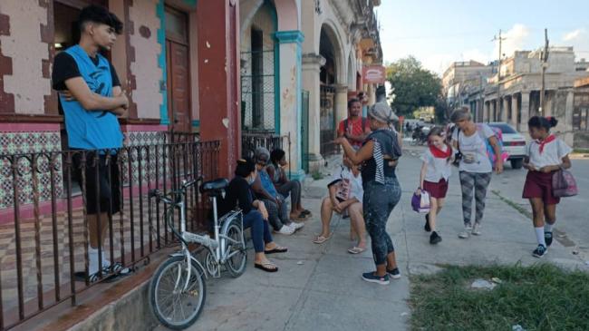 Varios cubanos frente a una escuela en La Habana.