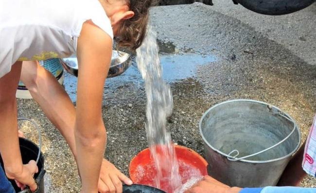 Cubanos reciben agua a través de un camión cisterna.