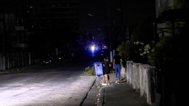 Una calle en apagón iluminada por la luz de carros, en La Habana.