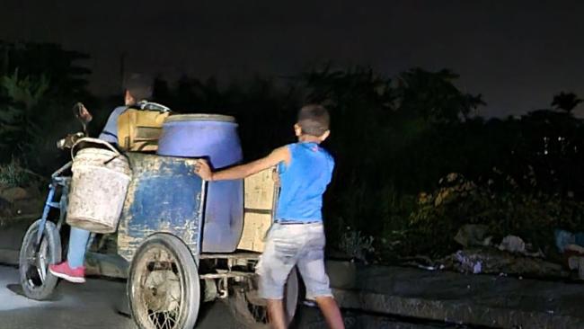 Un niño cubano en labores de carga durante un apagón.